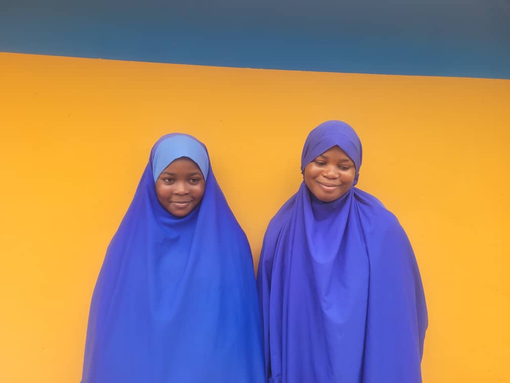 Female students in blue hijabs and uniforms
