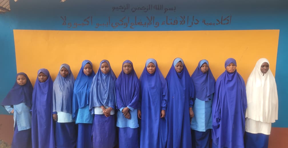 Large group of female students in blue hijabs and uniforms